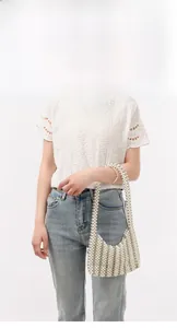Elegant beaded pearl shoulder bag styled with white lace top and casual denim jeans