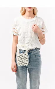 Sac à bandoulière en perles blanches fait main porté avec une tenue décontractée