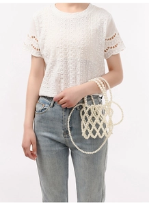 Détail du sac bandoulière fait main en perles avec texture tressée élégante crème