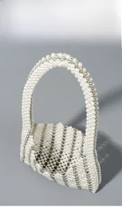 Detail of handmade woven pearl beaded handbag with white and silver beads in structured shape