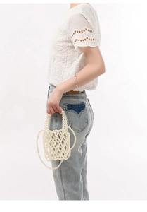 Détail d'un sac à bandoulière en perles blanches fait main avec poignée et sangle tissées
