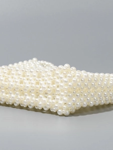 Sac à bandoulière en perles fait main avec des perles nacrées tissées sur fond neutre