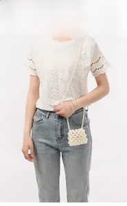 Detail shot of a handmade pearl woven mini crossbody bag with a long beaded shoulder strap