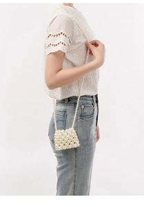 Detail of handmade pearl woven mini crossbody bag with large faux pearls for women