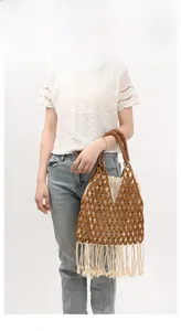 Close-up detail of wood bead weave with beige fabric lining and long cotton tassels
