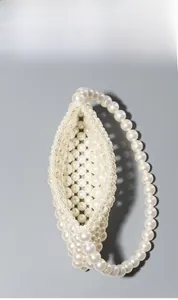 Top view of white pearl woven handbag showing interior space and handle details