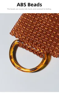 Dettaglio delle perle d'ambra tonde e del manico in resina di questa borsa tessuta