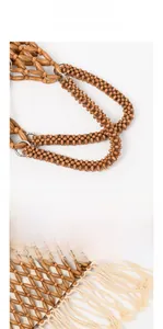 Detail showing polished wood beads handle and cream cotton tassel on woven tote bag