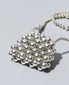 Top view of a handcrafted silver beaded bag with a metallic glossy finish and chain