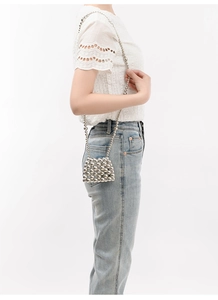 Detail of silver beaded handmade crossbody bag with woven pearls and chain strap