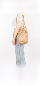 Detail of woven cotton shoulder bag with hollow mesh pattern and white inner liner bag