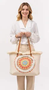 Detail of canvas tote bag showing colorful mandala embroidery and decorative fringe trim