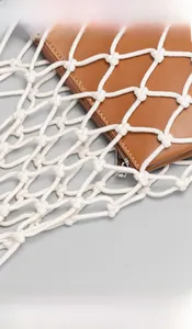 Detail of handmade woven cotton mesh bag featuring a brown leather inner lining with zipper