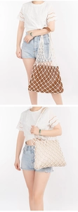 Detail of hand-woven cotton net bag with brown leather inner pouch for beach vacations