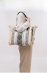 Close-up of bohemian canvas tote bag with ethnic geometric patterns and tassel details