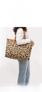 Leopard print canvas tote bag with brown leather straps and large capacity detail