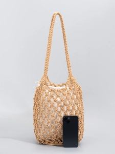 Handmade beige cotton woven mesh shoulder bag with a drawstring inner pouch and smartphone for scale