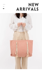 Détail d'un sac cabas tissé rose corail avec glands décoratifs et poignées en corde