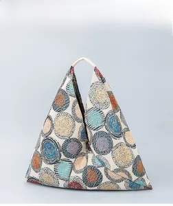 Detailed shot of triangular canvas tote with colorful geometric patterns and sturdy handles
