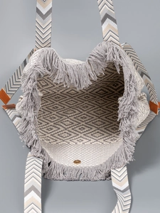 Bohemian geometric woven tote bag with fringe details and striped shoulder strap