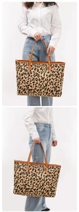 Detail view of large leopard print tote bag with brown leather handles and canvas texture