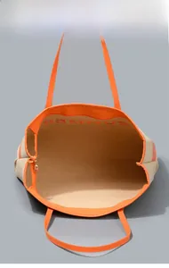 Vista dettagliata della borsa tote in tela con finiture arancioni e interno molto ampio