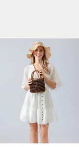 Detail of handmade woven wooden bead handbag in dark coffee brown for beach vacation
