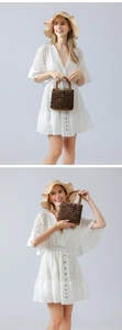 Detail of a handmade wooden bead handbag paired with a white lace dress for a summer vacation look