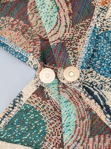 Detailed close-up of patterned canvas handbag with premium gold magnetic buckle hardware