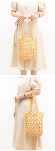 Detail of handmade woven beaded handbag featuring light yellow olive-shaped wooden beads