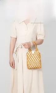 Detail of hand-woven wooden bead handbag with a white drawstring canvas inner bag