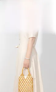 Detail of yellow handmade beaded tote bag with white drawstring liner and woven mesh