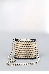 Detailed close-up of beaded bucket bag with black and white diamond woven grid pattern