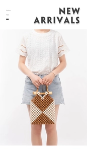 Detail of handmade woven beaded bag with geometric pattern and smooth wooden handles