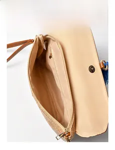 Detail of straw woven bag showing zipper pocket, magnetic closure, and inner lining