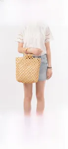 Detail of a handmade wooden bead woven handbag featuring a unique hollow mesh texture
