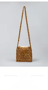 Detail of hand-woven brown wooden bead crossbody bag with a beige drawstring lining
