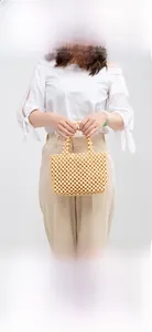 Detail of handmade wooden bead handbag showing intricate weaving and circular handles