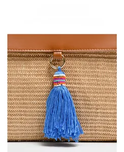 Detail of straw woven bag with vibrant blue tassel and colorful beads decoration