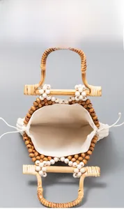 Detailed top view of handmade geometric beaded bag with bamboo handles and fabric lining