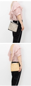 Detailed close-up of handmade woven bead crossbody bags in black, white and beige colors