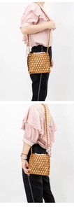 Detail view of woven wooden bead crossbody bag with interior drawstring fabric pouch