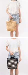 Close-up of handmade woven bead tote bag with circular wooden handles and hollow mesh design