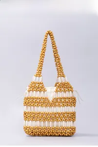 Detail of yellow and white beaded handbag with drawstring canvas liner and woven handle