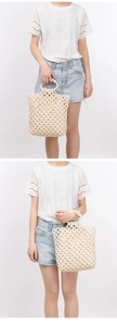 Detail of handmade cream beaded tote bag featuring elegant woven hollow grid pattern