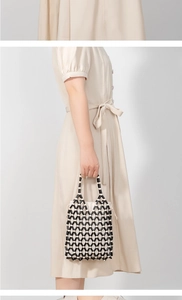 Detail of handmade beaded tote bag featuring black and white geometric diamond pattern