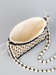 Woven crossbody bag with black and cream beads and a cotton drawstring liner