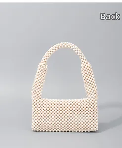 Detail view of the back of a white handcrafted beaded shoulder bag with wooden texture