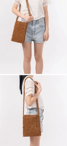 Detailed view of handmade dark brown wood bead crossbody bag with long shoulder strap
