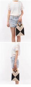 Detail of handmade woven beaded handbag featuring contrast patterns and natural bamboo handles